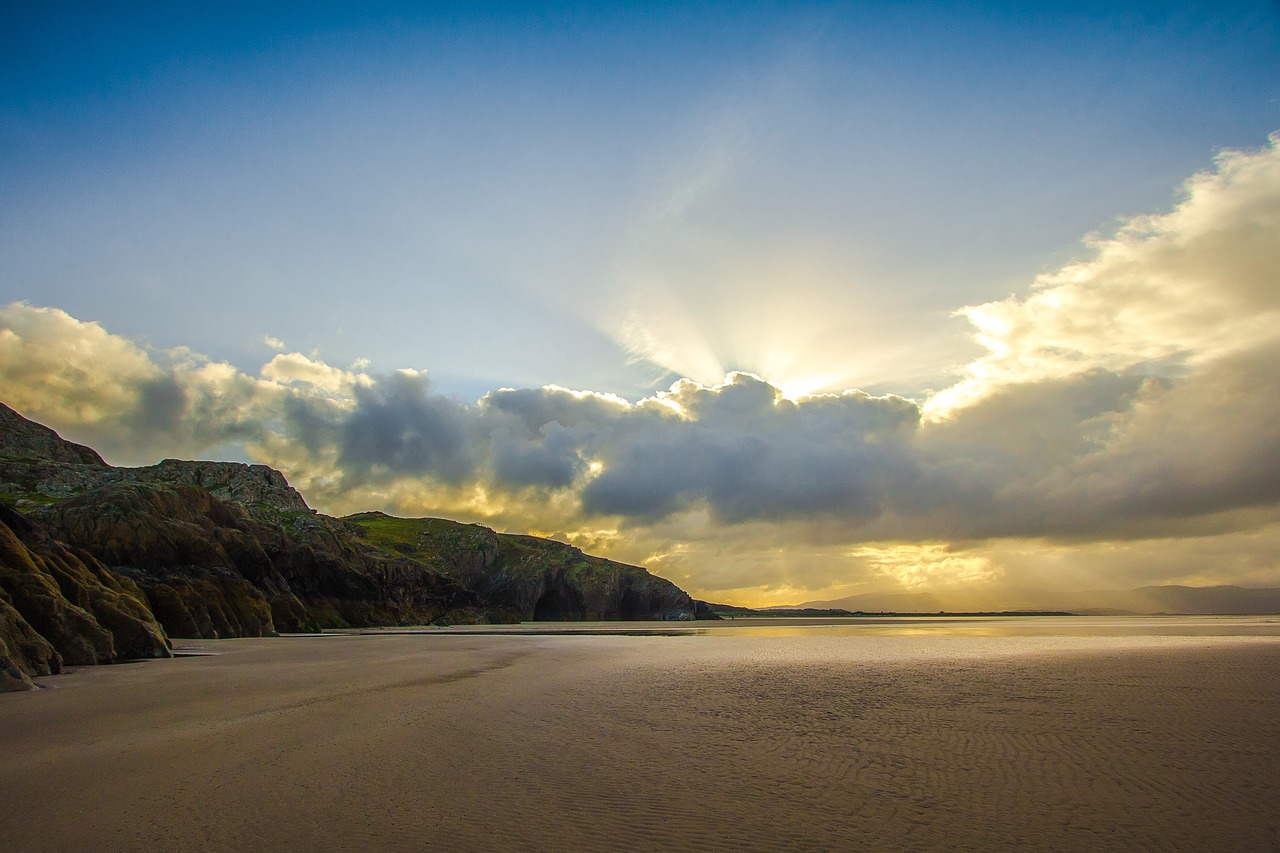 Image - beach sun rays ocean rocks clouds