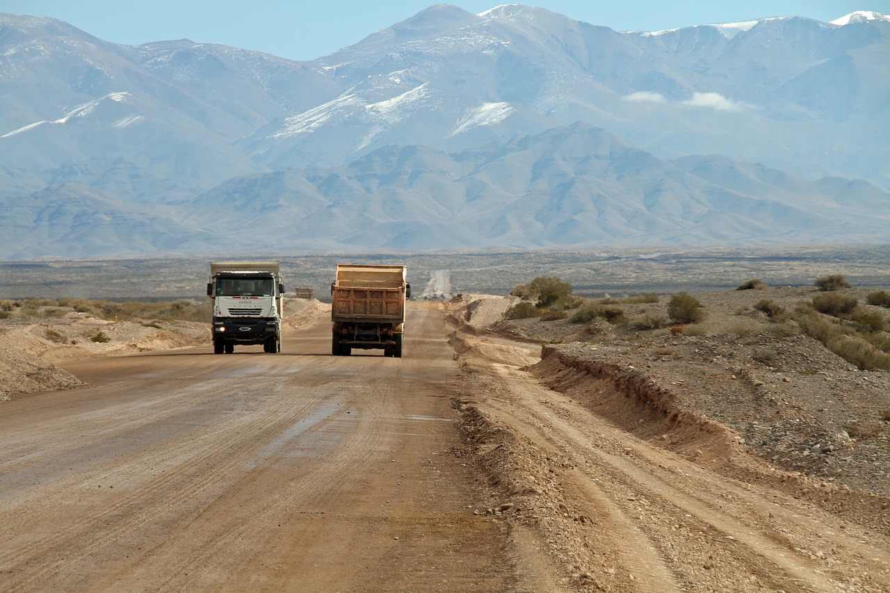 Image - dirt road trucks mountains heavy