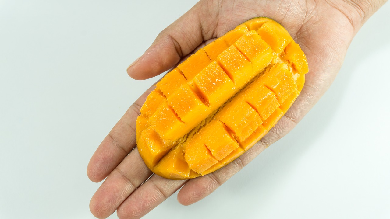 Image - mango slice on hand yellow