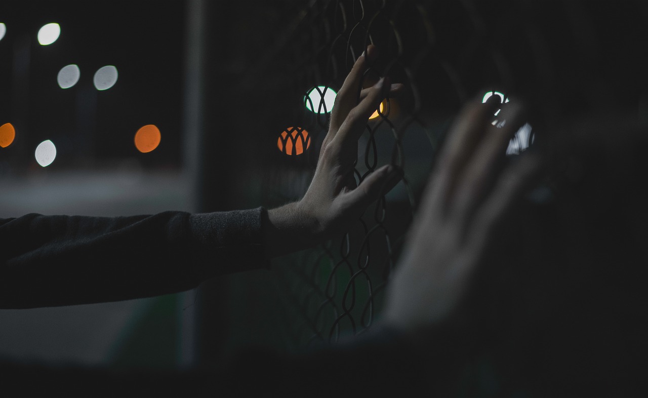 Image - hands bokeh fence lights night