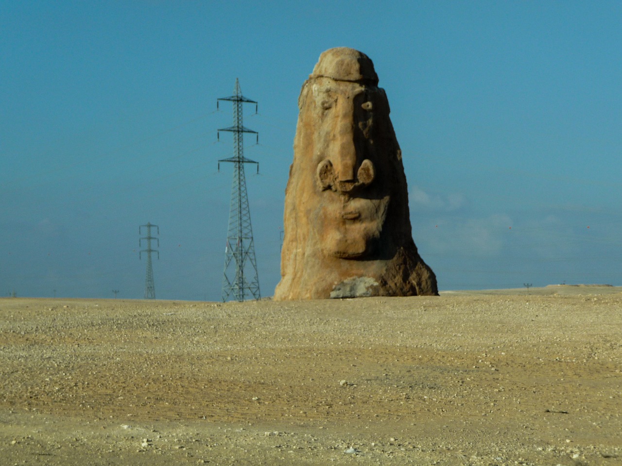 Image - carved stone rock face power lines