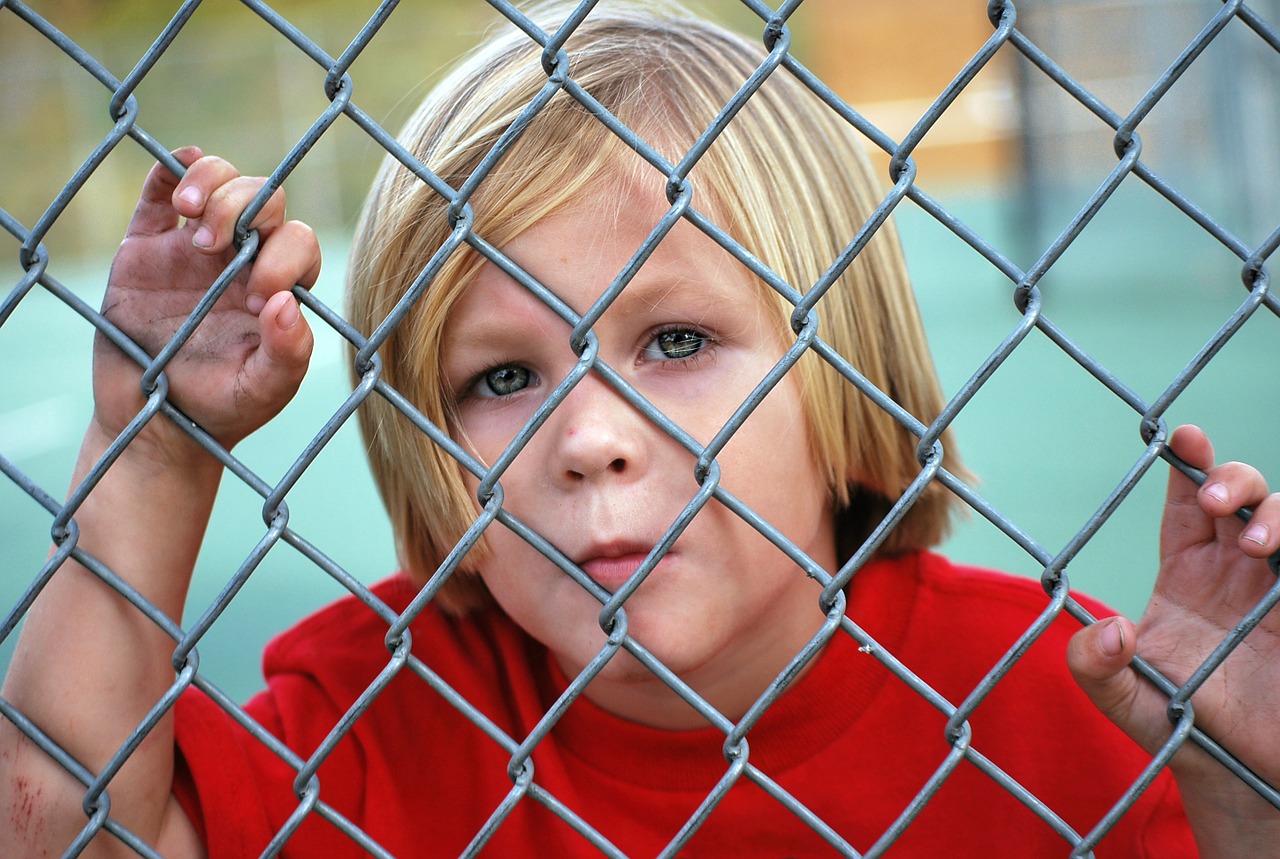 Image - boy looking fence chain link young