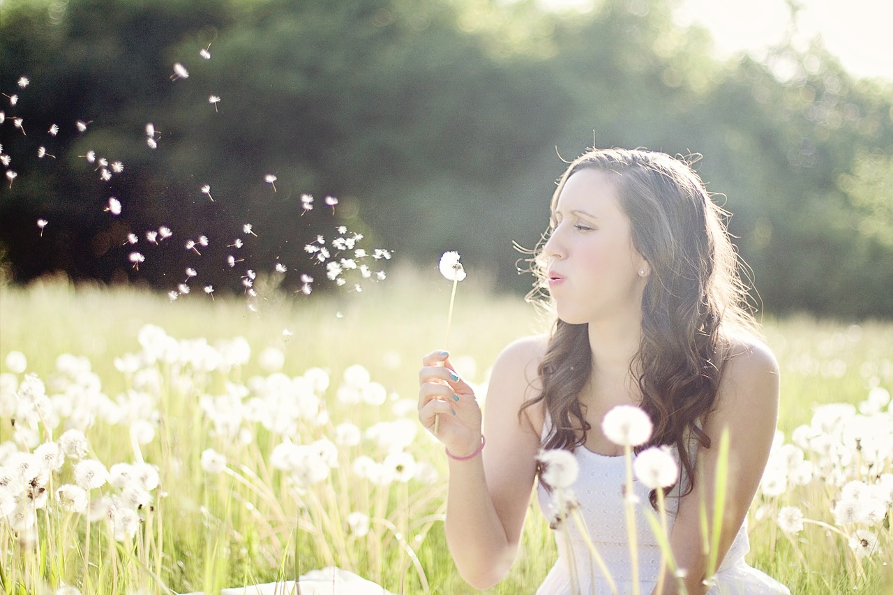 Image - dandelions woman blowing wind