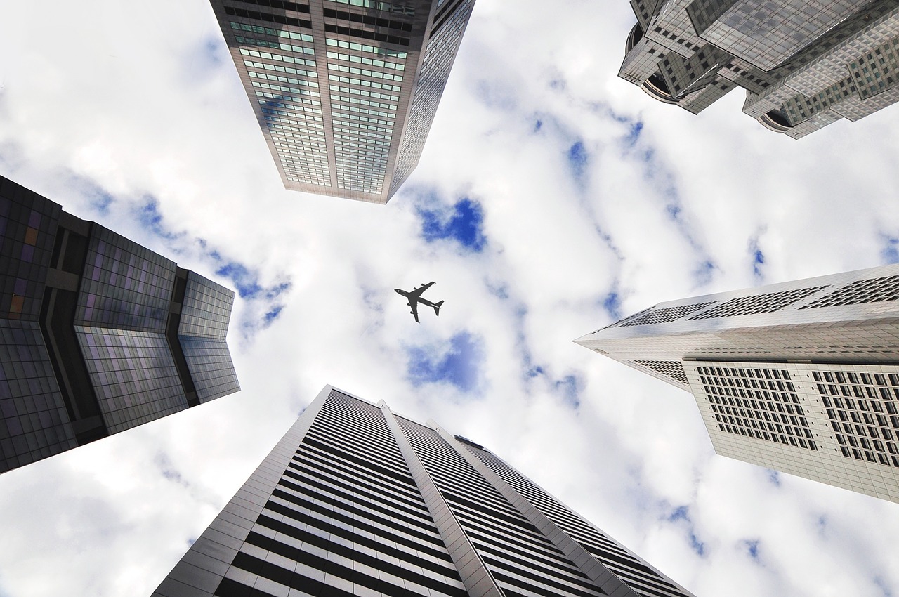 Image - airplane sky buildings towers