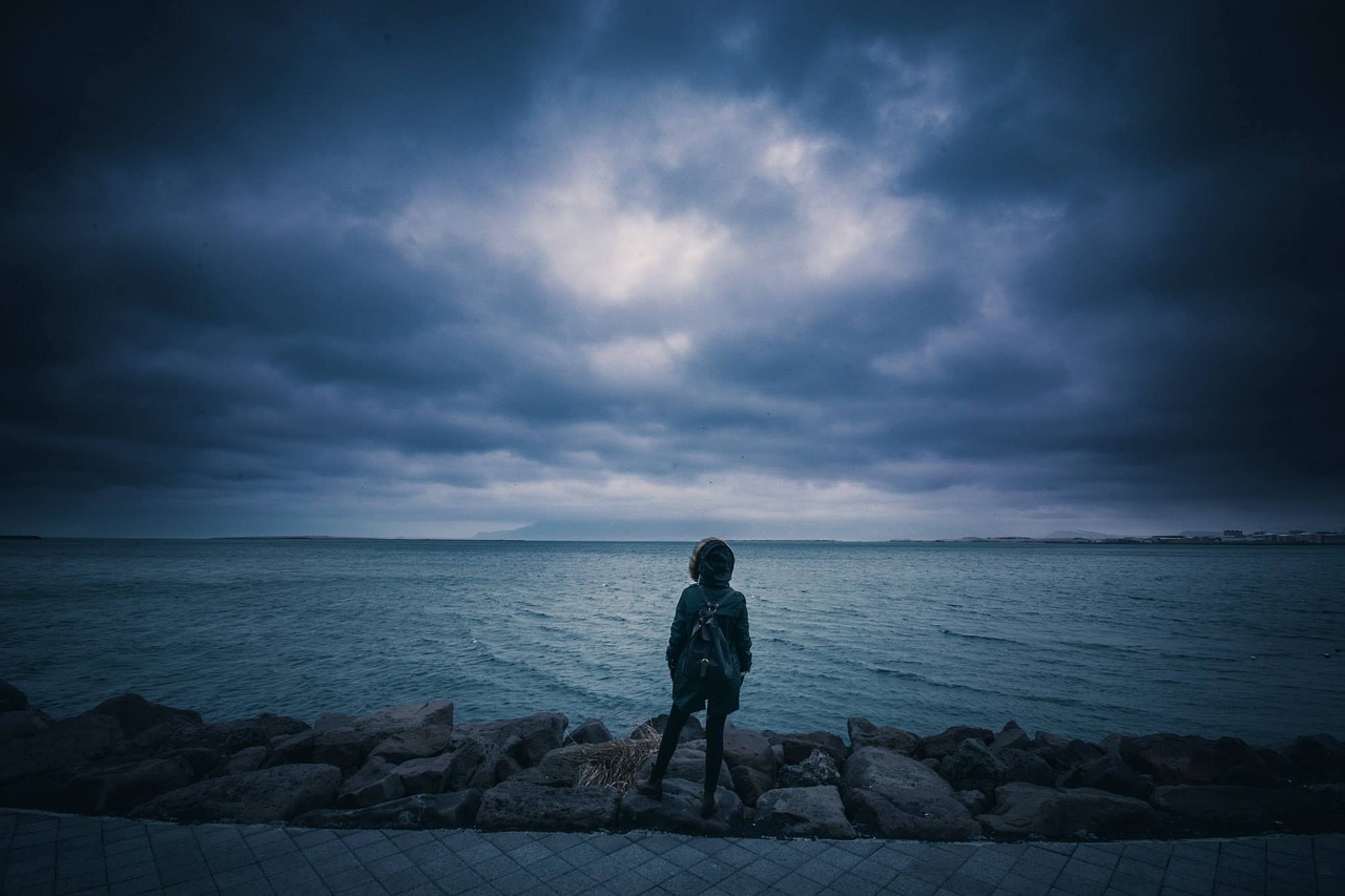 Image - person standing shore coast stones