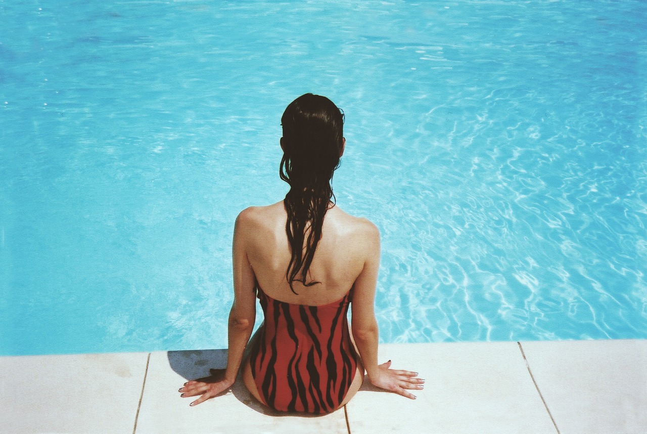 Image - woman sitting poolside swimming