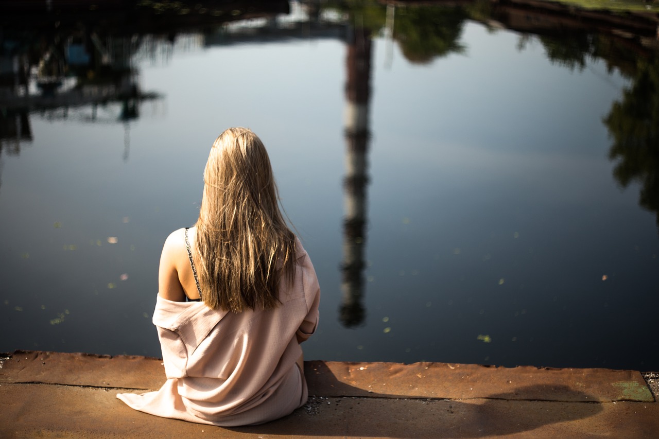 Image - girl blonde sitting lakeside water